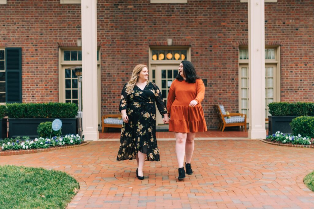 LGBTQ couple walking while holding hands in front of the Carolina Inn